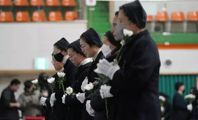 Nuns pray for the victims of a plane fire at a memorial altar at Muan sport park in Muan, South Korea, Monday, Dec. 30, 2024. (AP Photo/Ahn Young-joon)