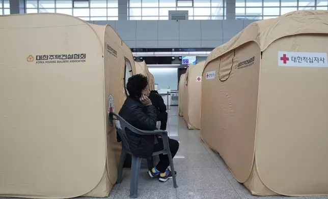 A relative of a passenger of a plane which burst into flames, reacts at a temporary shelter at Muan International Airport in Muan, South Korea, Monday, Dec. 30, 2024. (AP Photo/Ahn Young-joon)