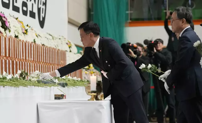 South Korea's acting President Choi Sang-mok places a flower for the victims on a plane which skidded off a runway and burst into flames, at a memorial altar at Muan sport park in Muan, South Korea, Monday, Dec. 30, 2024. (AP Photo/Ahn Young-joon)