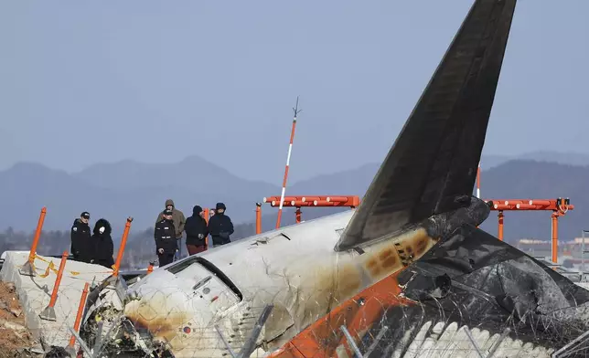 Experts from the U.S. National Transportation Safety Board (NTSB) and joint investigation team between the U.S. and South Korea check the site of a plane crash at Muan International Airport in Muan, South Korea, Tuesday, Dec. 31, 2024. (Son Hyung-joo/Yonhap via AP)