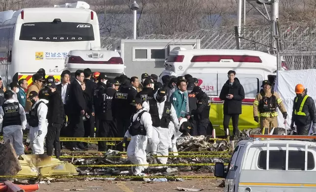 South Korea's acting President Choi Sang-mok, wearing a green jacket, visits the site of a plane fire at Muan International Airport in Muan, South Korea, Monday, Dec. 30, 2024. (AP Photo/Ahn Young-joon)