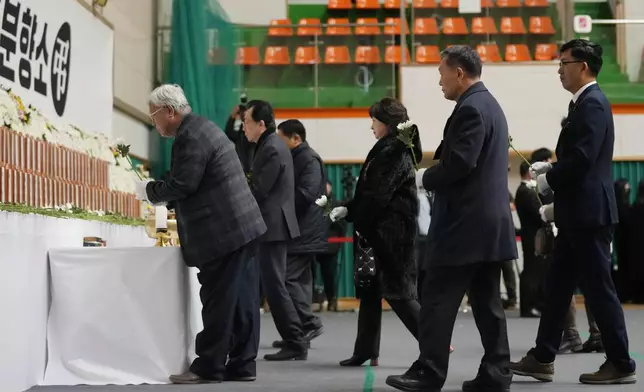 Mourners place flowers for the victims of a plane fire at a memorial altar at Muan sport park in Muan, South Korea, Monday, Dec. 30, 2024. (AP Photo/Ahn Young-joon)