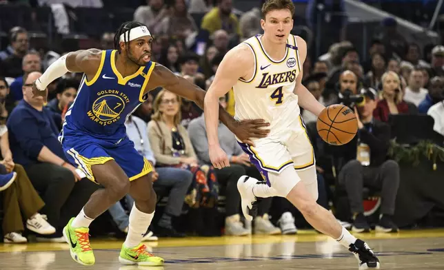 Los Angeles Lakers guard Dalton Knecht (4) dribbles against Golden State Warriors guard Buddy Hield (7) during the first half of an NBA basketball game, Wednesday, Dec. 25, 2024, in San Francisco. (AP Photo/Eakin Howard)