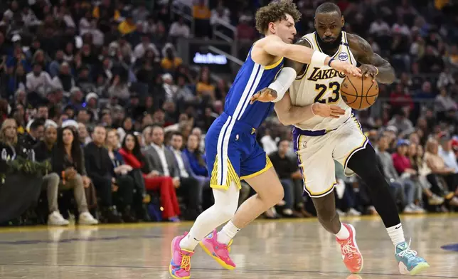 Los Angeles Lakers forward LeBron James (23) drives to the basket against Golden State Warriors guard Brandin Podziemski (2) during the first half of an NBA basketball game Wednesday, Dec. 25, 2024, in San Francisco. (AP Photo/Eakin Howard)