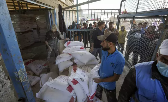 Donated flour is distributed to Palestinians at a UNRWA center in the Nuseirat refugee camp, Gaza Strip, Tuesday Dec. 3, 2024.(AP Photo/Abdel Kareem Hana)