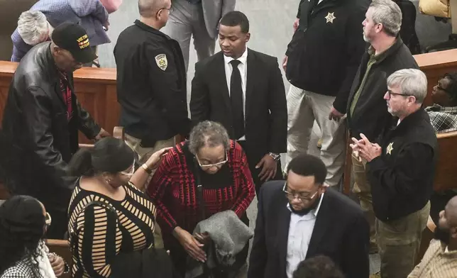 Sheldon "Timothy" Herrington Jr., center, who was on trial for the murder of University of Mississippi student Jimmie "Jay" Lee, joins family as they leave court after a mistrial was declared, at the Lafayette County Courthouse in Oxford, Miss. on Wednesday, Dec. 11, 2024. (Bruce Newman/The Northeast Mississippi Daily Journal, via AP, Pool)