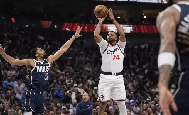 Los Angeles Clippers guard Norman Powell (24) shoots against Dallas Mavericks guard Spencer Dinwiddie (26) during the first half of an NBA basketball game, Saturday, Dec. 21, 2024, in Dallas. (AP Photo/LM Otero)