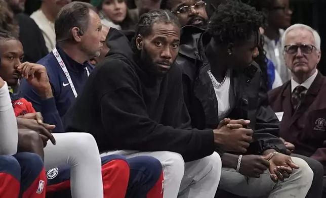 Los Angeles Clippers forward Kawhi Leonard watches from the bench during the first quarter of an NBA basketball game against the Dallas Mavericks, Saturday, Dec. 21, 2024, in Dallas. (AP Photo/LM Otero)