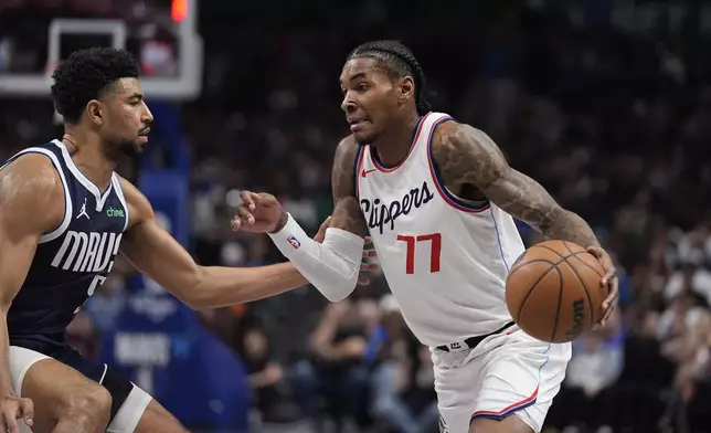 Los Angeles Clippers guard Kevin Porter Jr. (77) dribbles against Dallas Mavericks guard Quentin Grimes (5) during the first period of an NBA basketball game Saturday, Dec. 21, 2024, in Dallas. (AP Photo/LM Otero)