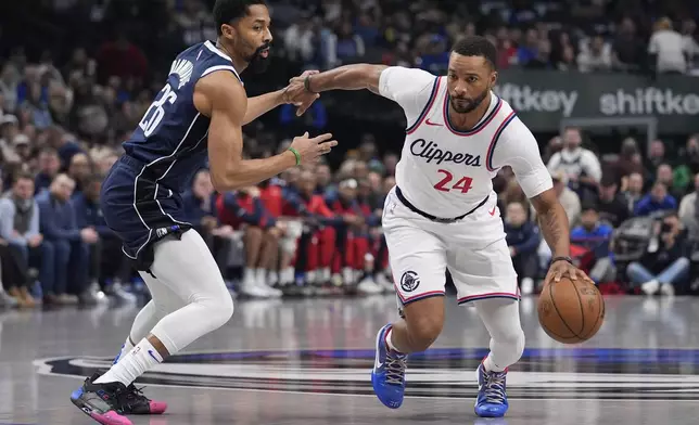 Los Angeles Clippers guard Norman Powell (24) drives against Dallas Mavericks guard Spencer Dinwiddie (26) during the first period of an NBA basketball game Saturday, Dec. 21, 2024, in Dallas. (AP Photo/LM Otero)