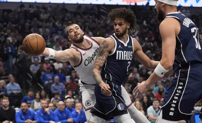 Los Angeles Clippers center Ivica Zubac (40) reaches for the ball against Dallas Mavericks center Dereck Lively II (2) and guard Klay Thompson (31) during the first period of an NBA basketball game Saturday, Dec. 21, 2024, in Dallas. (AP Photo/LM Otero)