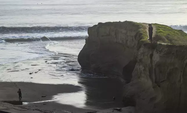 Police officers, right, look for building remnants on Seabright State Beach during high surf in Santa Cruz, Calif., Monday, Dec. 23, 2024. (AP Photo/Nic Coury)