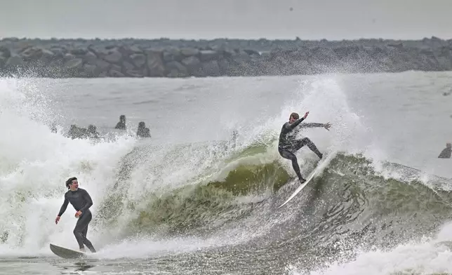 Surfers take to the water as big waves hit the shore in Seal Beach, Calif., Monday, Dec, 23, 2024. (Jeff Gritchen/The Orange County Register via AP)