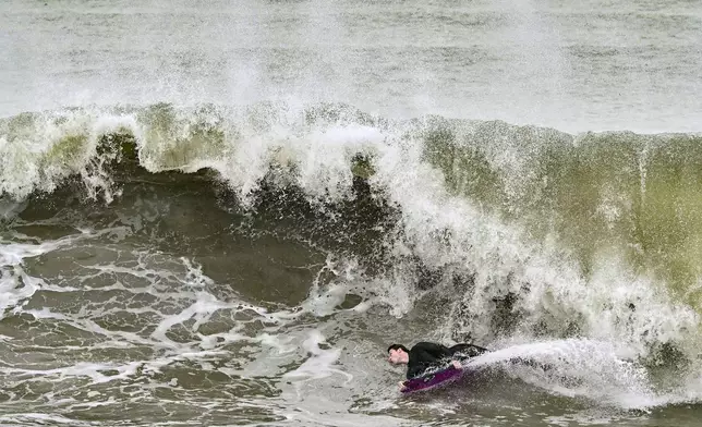 Surfers take to the water as big waves hit the shore in Seal Beach, Calif., Monday, Dec. 23, 2024. (Jeff Gritchen/The Orange County Register via AP)