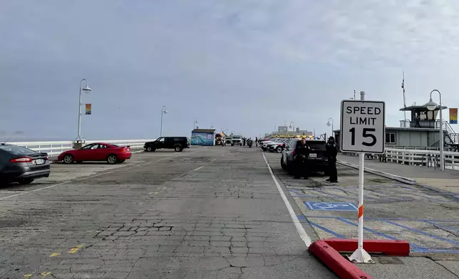 Law enforcement officers close off the Santa Cruz, Calif., wharf Monday, Dec. 23, 2024, after the pier partially collapsed and fell into the ocean. (AP Photo/Martha Mendoza)