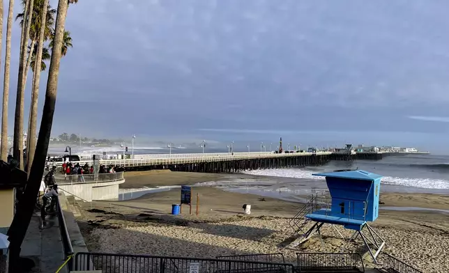 Bystanders looks out at a closed Santa Cruz wharf after the pier partially collapsed and fell into the ocean on Monday, Dec. 23, 2024 in Santa Cruz, Calif. (AP Photo/Martha Mendoza)