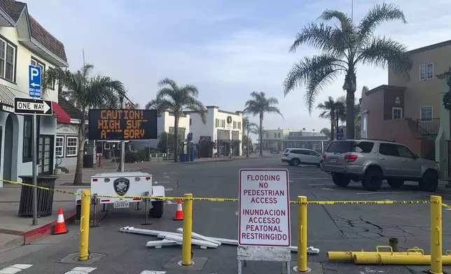 A street is closed due to high surf conditions near Capitola Beach, Monday, Dec. 23, 2024, in Capitola, Calif. (AP Photo/Pamela Hassell)