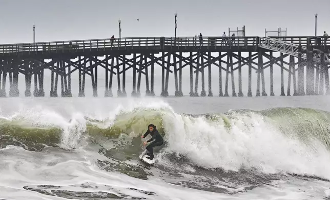 Surfers take to the water as big waves hit the shore in Seal Beach, Calif., Monday, Dec. 23, 2024. (Jeff Gritchen/The Orange County Register via AP)