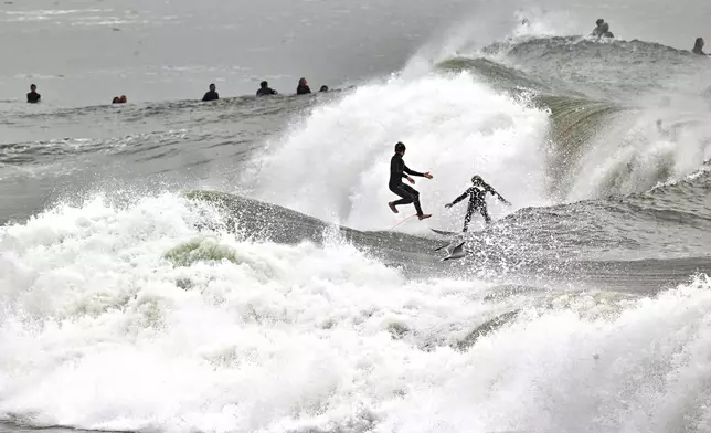 Surfers take to the water as big waves hit the shore in Seal Beach, Calif., Monday, Dec. 23, 2024. (Jeff Gritchen/The Orange County Register via AP)