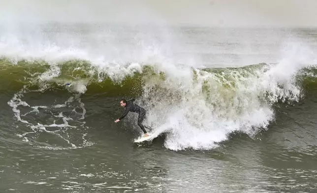 Surfers take to the water as big waves hit the shore in Seal Beach, Calif., Monday, Dec. 23, 2024. (Jeff Gritchen/The Orange County Register via AP)