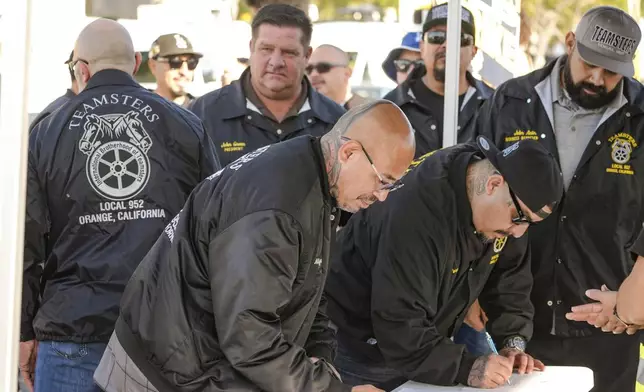 Teamsters Local 952 members sign-in as they join Amazon workers striking outside the gates of an Amazon Fulfillment Center, Thursday, Dec. 19, 2024, in City of Industry, Calif. (AP Photo/Damian Dovarganes)