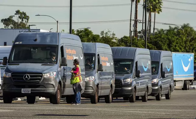 Amazon drivers wait in line before departing to deliver goods as Amazon workers picket outside the gates of an Amazon Fulfillment Center, Thursday, Dec. 19, 2024, in City of Industry, Calif. (AP Photo/Damian Dovarganes)