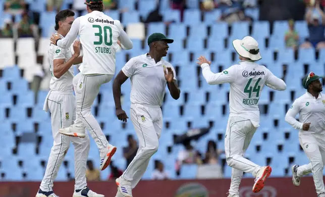 South Africa's Marco Jansen, left, celebrates with his teammates after dismissing Pakistan's Babar Azam for 50 runs during day three of the Test cricket match between South Africa and Pakistan, at the Centurion Park in Centurion, South Africa, Saturday, Dec. 28, 2024. (AP Photo/Themba Hadebe)