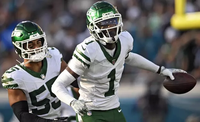 New York Jets cornerback Sauce Gardner (1) celebrates with linebacker Chazz Surratt (55) after Gardner intercepted a pass against the Jacksonville Jaguars during the second half of an NFL football game Sunday, Dec. 15, 2024, in Jacksonville, Fla. (AP Photo/Phelan M. Ebenhack)