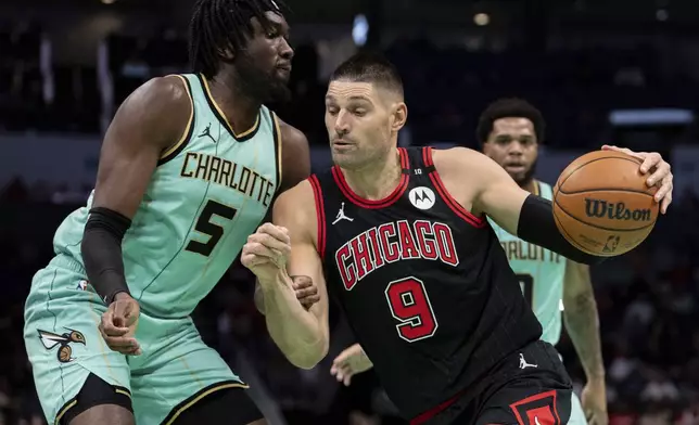 Charlotte Hornets center Mark Williams (5) defends against Chicago Bulls center Nikola Vucevic (9) during the first half of an NBA basketball game in Charlotte, N.C., Monday, Dec. 30, 2024. (AP Photo/Jacob Kupferman)