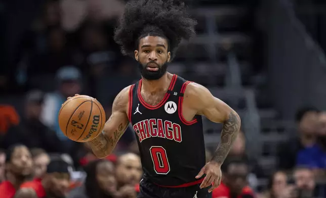 Chicago Bulls guard Coby White (0) brings the ball upcourt during the first half of an NBA basketball game against the Charlotte Hornets in Charlotte, N.C., Monday, Dec. 30, 2024. (AP Photo/Jacob Kupferman)