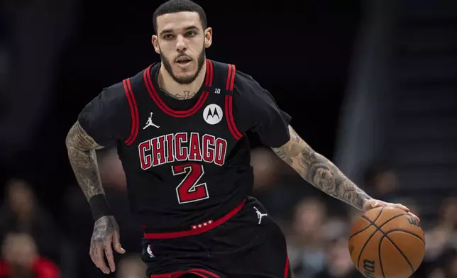 Chicago Bulls guard Lonzo Ball (2) brings the ball upcourt during the first half of an NBA basketball game against the Charlotte Hornets in Charlotte, N.C., Monday, Dec. 30, 2024. (AP Photo/Jacob Kupferman)