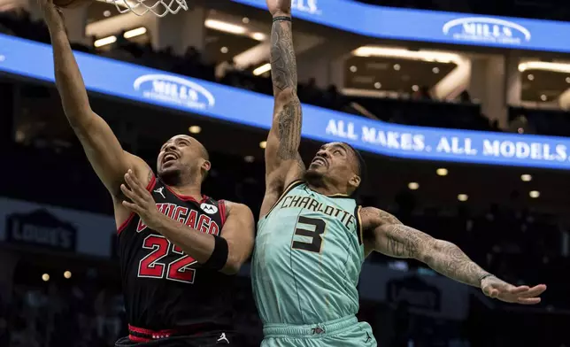 Charlotte Hornets guard Vasilije Micic (22) drives to the basket while guarded by Charlotte Hornets guard DaQuan Jeffries (3) during the first half of an NBA basketball game in Charlotte, N.C., Monday, Dec. 30, 2024. (AP Photo/Jacob Kupferman)