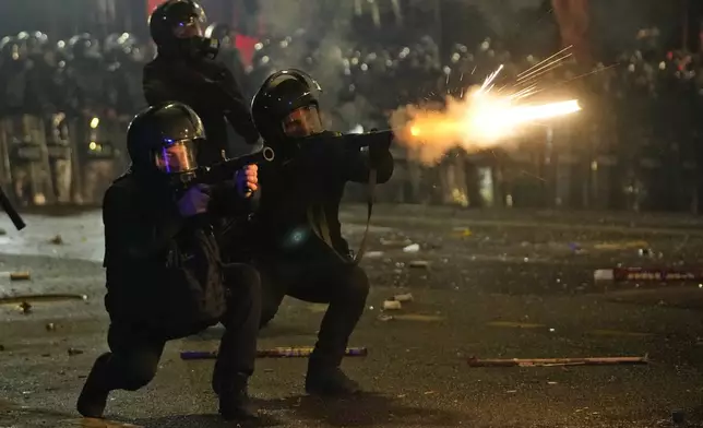 FILE - Police shoot tear gas towards demonstrators during a protest against the government's decision to suspend negotiations on joining the European Union in Tbilisi, Georgia, early Wednesday, Dec. 4, 2024. (AP Photo/Pavel Bednyakov, File)