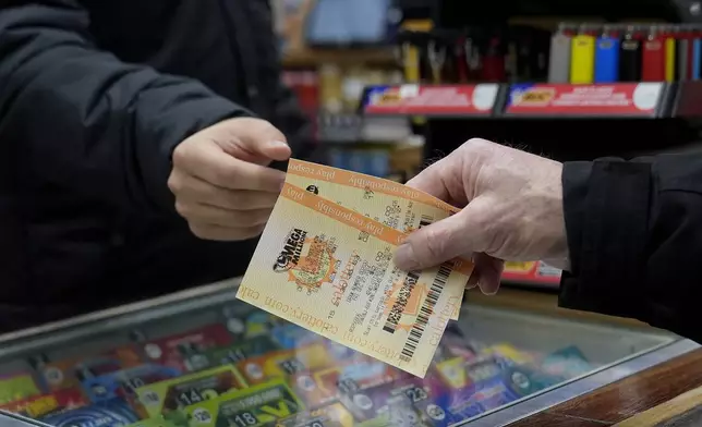 Rob, right, buys a Mega Millions ticket at Rossi's Deli in San Francisco, Thursday, Dec. 26, 2024. (AP Photo/Jeff Chiu)