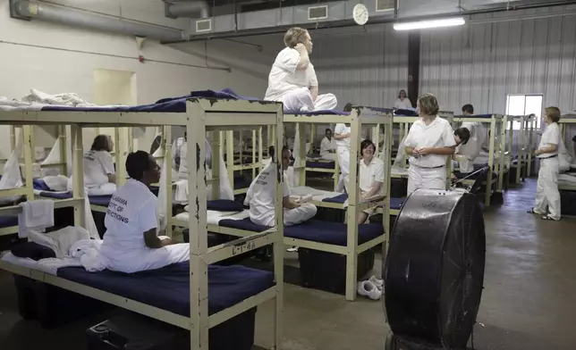 FILE -- In this Sept. 23, 2013, file photo, inmates sit on their bunks in a dorm at Tutwiler Prison for Women in Wetumpka, Ala. (AP Photo/Dave Martin, File)