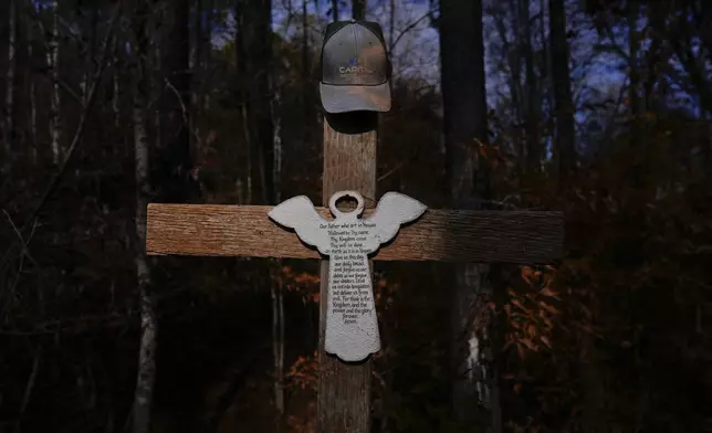 Willie Crayton's hat hangs on a cross bearing the Lord's Prayer and marking the location along Elder Road, Thursday, Dec. 5, 2024, in Dadeville, Ala, where the Alexander City Community Work Center transport van he was riding in crashed in April 2024, killing Crayton and Bruce Clements. (AP Photo/Carolyn Kaster)