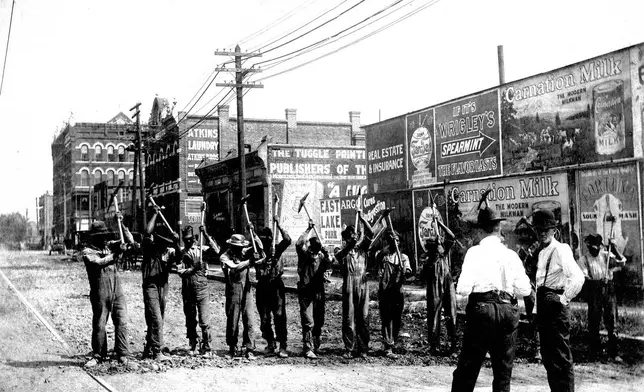 This August 10, 1909 photo shows convicts engaged in street repair on 24th Street while under the watch of guards in Birmingham, Ala. (Birmingham, Ala., Public Library Archives via AP)