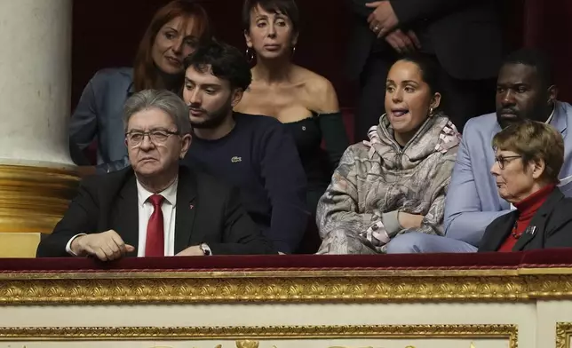 French far-left leader Jean-Luc Melenchon, left, listens to speeches from the tribunes at the National Assembly prior to a no-confidence vote that could bring down the Prime Minister and the government for the first time since 1962, Wednesday, Dec. 4, 2024 in Paris. (AP Photo/Michel Euler)