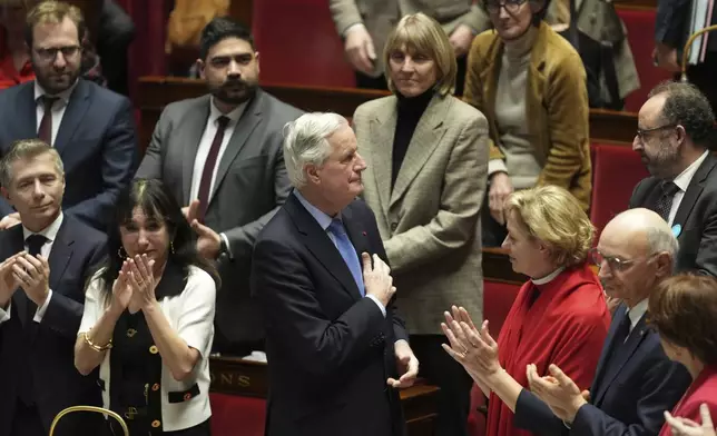 French Prime Minister Michel Barnier gets applause from ministers and parliament members after addressing the National Assembly prior to a vote on a no-confidence motion that could bring him down and his cabinet for the first time since 1962, Wednesday, Dec. 4, 2024 in Paris. (AP Photo/Michel Euler)