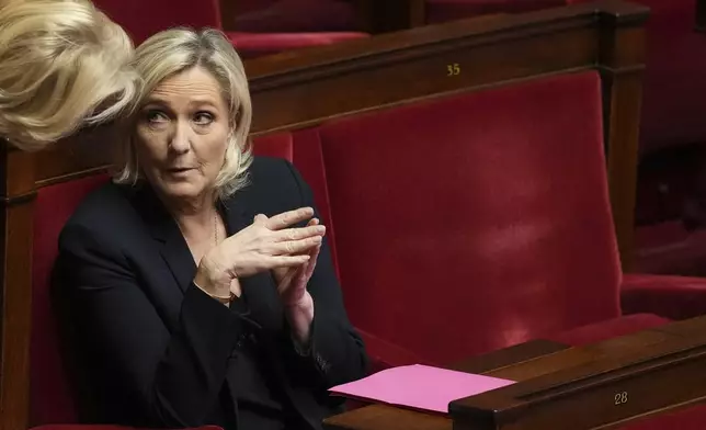 French far-right leader Marine Le Pen sits at the National Assembly before French lawmakers vote on a no-confidence motion that could bring down the Prime Minister and the government for the first time since 1962, Wednesday, Dec. 4, 2024 in Paris. (AP Photo/Michel Euler)