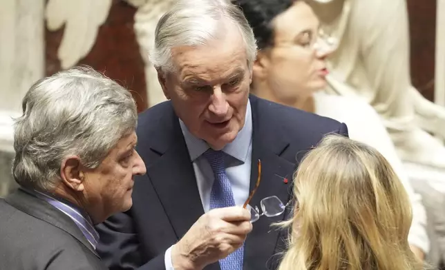 French Prime Minister Michel Barnier, center, talks to people at the National Assembly before French lawmakers vote on a no-confidence motion that could bring down the prime minister and the government for the first time since 1962, Wednesday, Dec. 4, 2024 in Paris. (AP Photo/Michel Euler)