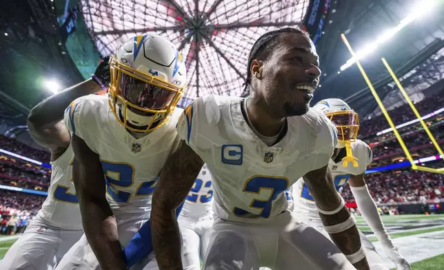 Los Angeles Chargers safety Derwin James Jr. (3) celebrates with teammates after an interception during the second half of an NFL football game against the Atlanta Falcons on Sunday, Dec. 1, 2024 in Atlanta. (AP Photo/Danny Karnick)