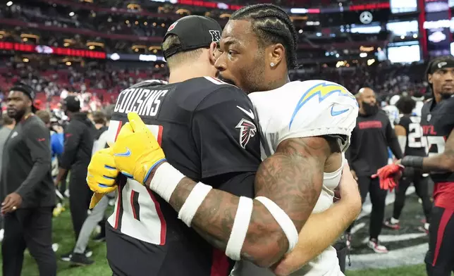 Los Angeles Chargers safety Derwin James Jr. (3) hugs Atlanta Falcons quarterback Kirk Cousins (18) after an NFL football game on Sunday, Dec. 1, 2024 in Atlanta. (AP Photo/Mike Stewart)