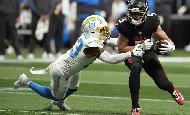 Atlanta Falcons wide receiver Drake London (5) runs the ball after making a catch against Los Angeles Chargers safety Tony Jefferson (23) during the second half of an NFL football game on Sunday, Dec. 1, 2024 in Atlanta. (AP Photo/Mike Stewart)