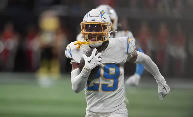 Los Angeles Chargers cornerback Tarheeb Still (29) returns an interception for a touchdown during the second half of an NFL football game against the Atlanta Falcons on Sunday, Dec. 1, 2024 in Atlanta. (AP Photo/Mike Stewart)