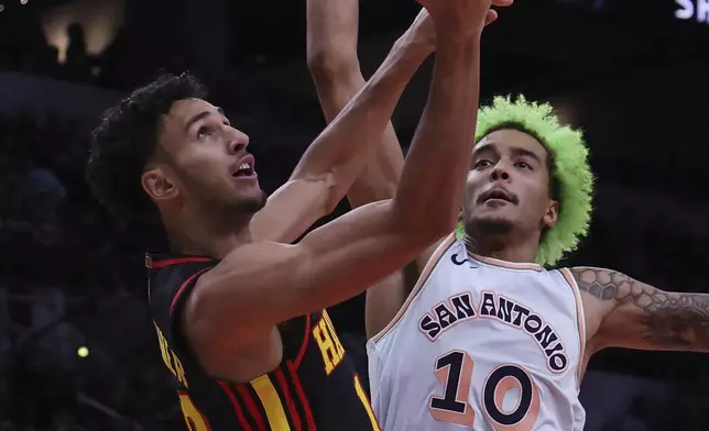 Atlanta Hawks forward Zaccharie Risacher, left, attempts a shot against San Antonio Spurs forward Jeremy Sochan (10) during the first half of an NBA basketball game in San Antonio, Thursday, Dec. 19, 2024. (AP Photo/Kin Man Hui)