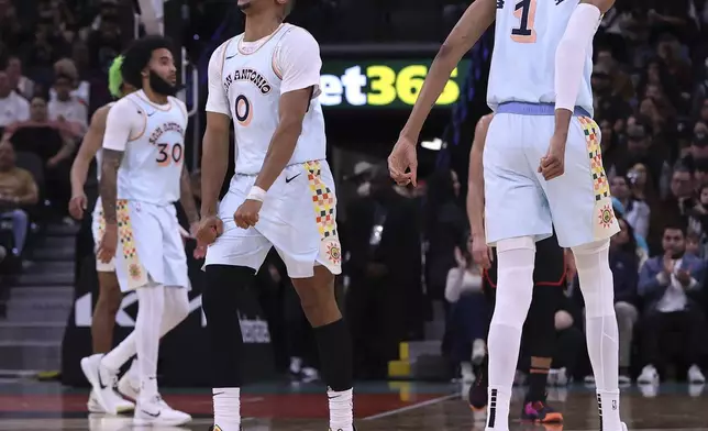 San Antonio Spurs forward Keldon Johnson (0) reacts after the Spurs score on the Atlanta Hawks during the first half of an NBA basketball game in San Antonio, Thursday, Dec. 19, 2024. (AP Photo/Kin Man Hui)