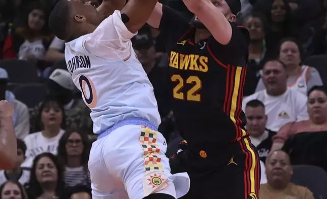 San Antonio Spurs forward Keldon Johnson (0) attempts a shot against Atlanta Hawks forward Larry Nance Jr. (22) during the first half of an NBA basketball game in San Antonio, Thursday, Dec. 19, 2024. (AP Photo/Kin Man Hui)