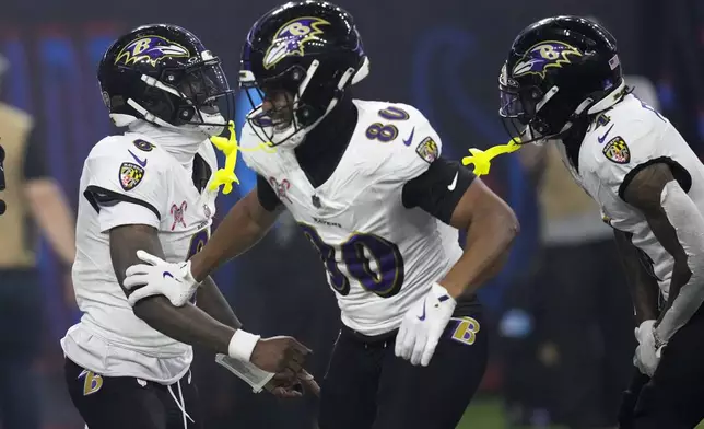 Baltimore Ravens quarterback Lamar Jackson, left, celebrates with teammates after a 48-yard touchdown run during the second half of an NFL football game against the Houston Texans, Wednesday, Dec. 25, 2024, in Houston. (AP Photo/David J. Phillip)