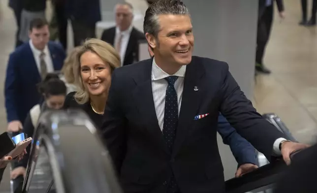 Pete Hegseth, President-elect Donald Trump's nominee to be defense secretary, is joined by his wife Jennifer Rauchet, as they walk through the basement of the Capitol, Wednesday, Dec. 4, 2024, in Washington. (AP Photo/Mark Schiefelbein)